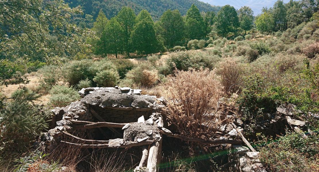 Imagen con restos de antiguas estructuras abandonadas próximas al sendero